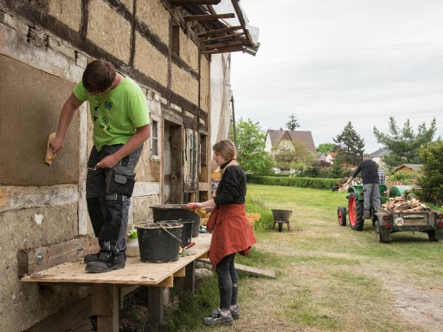 Auf der Südseite des Hauses verputzen Teilnehmende die alten Gefache | Foto: Hendrik Silbermann (ARTWORKs) Die Gefache der Fassade des Ernhaus werden bereits verputzt