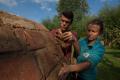 Zwei Workcamp Teilnehmende bauen einem Lehmbackofen