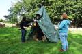 Workcamp-Teilnehmende bauen eine Hütte aus einer Plane.