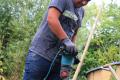 Ein Workcamp-Teilnehmender mischt Lehm.